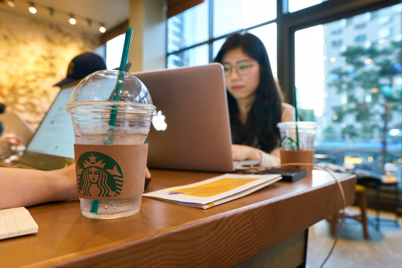 Freelancer using laptop at Starbucks
